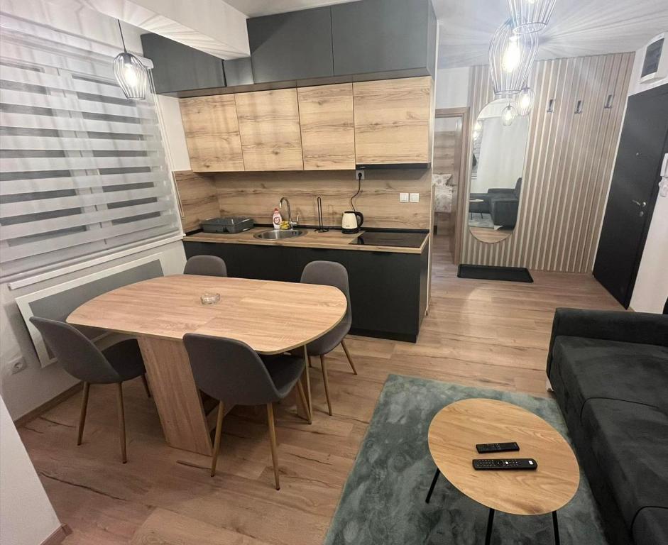 a kitchen and living room with a table and a couch at Apartmani NIX VIR in Jahorina