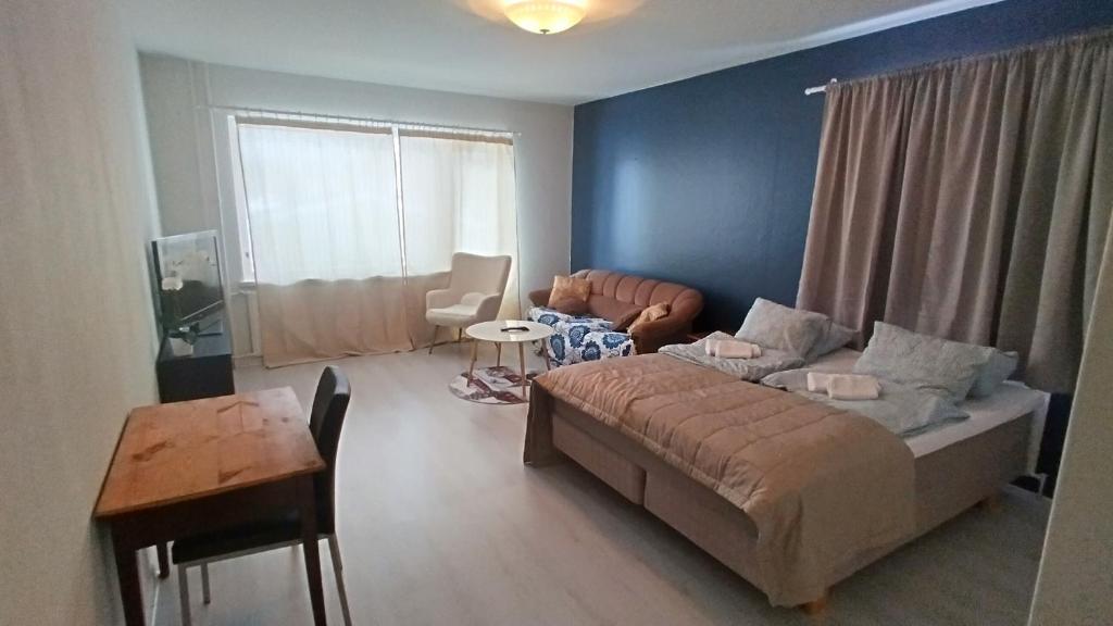 Sala de estar con cama y mesa en Rauma City Apartments, en Rauma