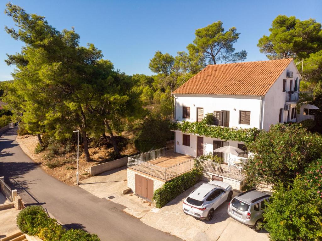 una vista aérea de una casa blanca con dos coches aparcados en Apartments Iskra, en Vrboska