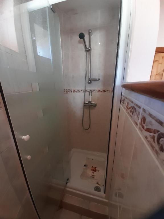 a shower with a glass door in a bathroom at Le four au pain in Esclauzels