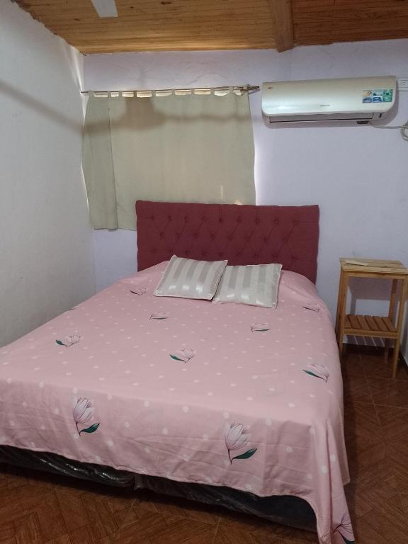 a bed in a room with a pink bedspread at Don José in Posadas