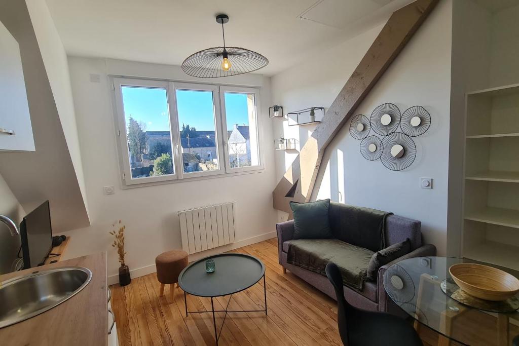 ein Wohnzimmer mit Sofa und Tisch in der Unterkunft Le Jaures 6 - T2 - Dernier Etage in Hennebont