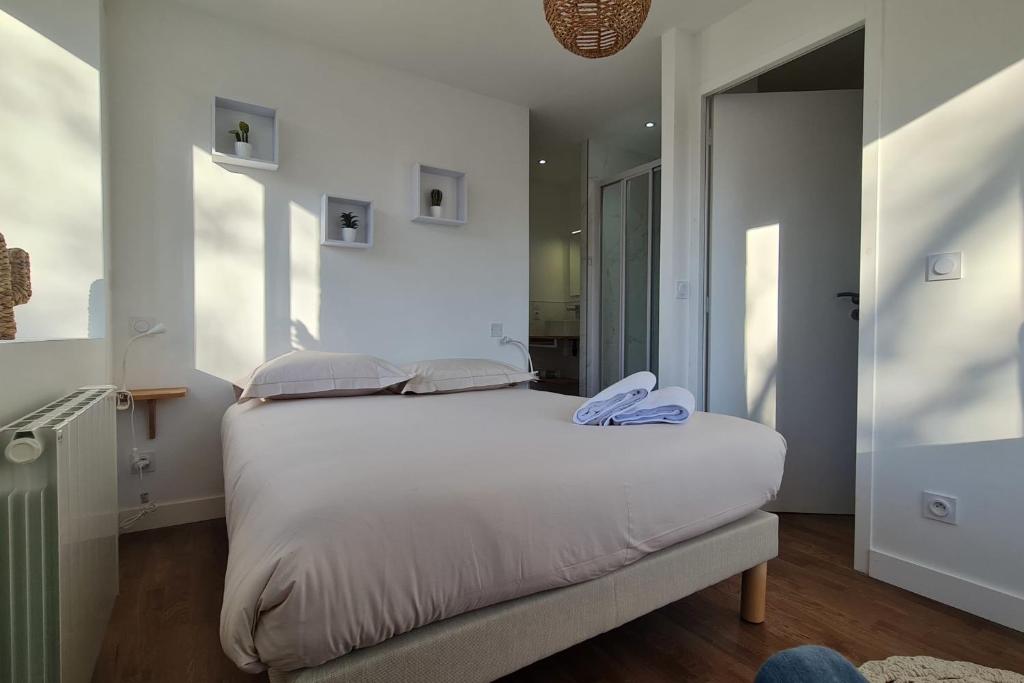 een slaapkamer met een wit bed en blauwe handdoeken. bij Le Jaures 2 - T2 - RDC in Hennebont
