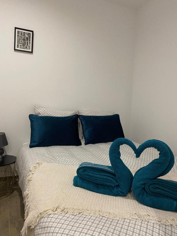 łóżko z dwoma ręcznikami w kształcie serca w obiekcie Studio au calme. w Marsylii