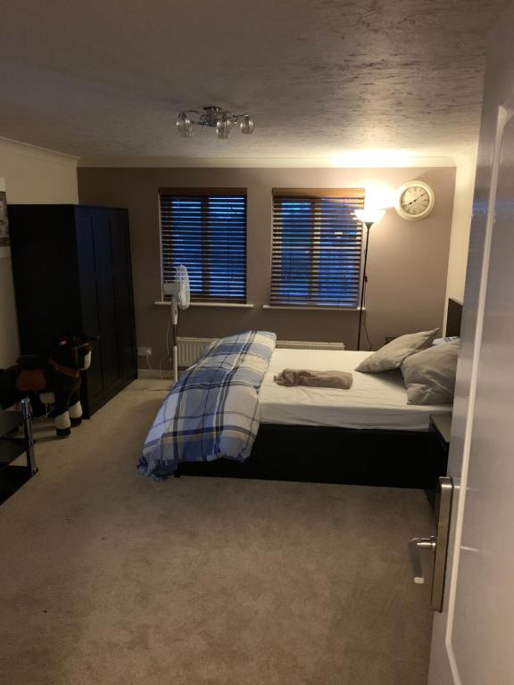 a bedroom with a bed with a blue blanket on it at Thames River Side Townhouse in Thamesmead