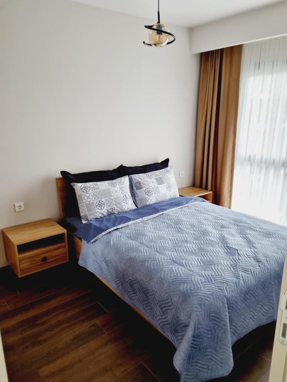 Un dormitorio con una cama azul y una ventana en Otto Residences City Center 216, en Estambul