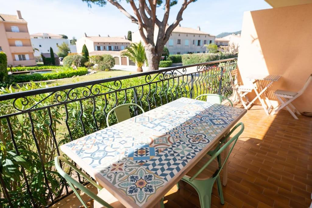 a table and chairs sitting on a balcony at Les Jardins de Provence • Beau Rivage • Proche mer in Carqueiranne