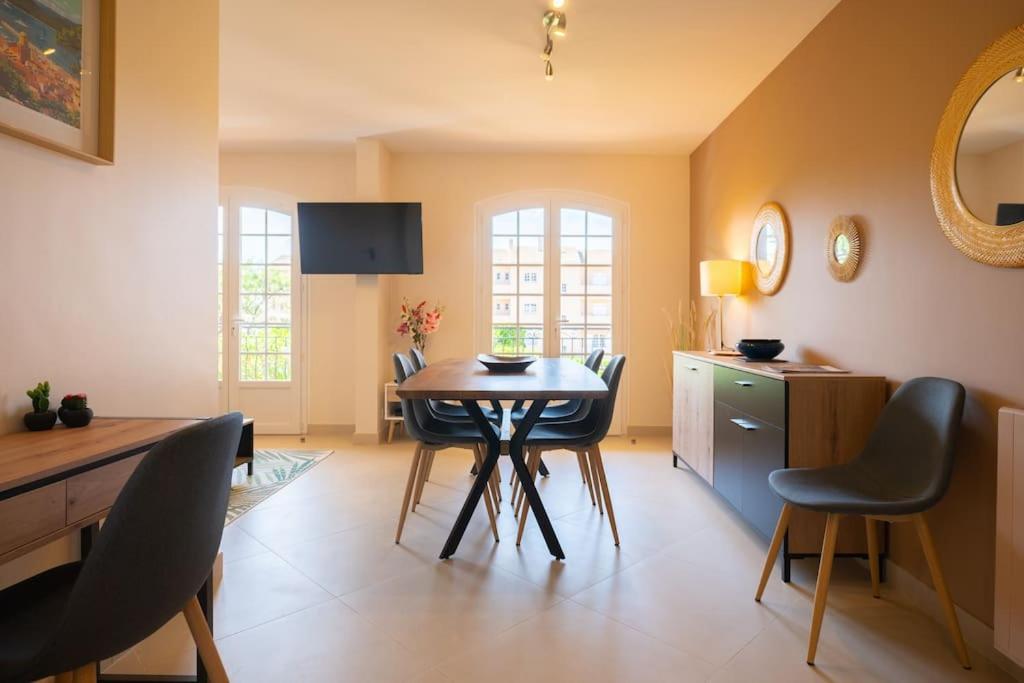 a kitchen with a table and chairs in a room at Les Jardins de Provence • Beau Rivage • Proche mer in Carqueiranne