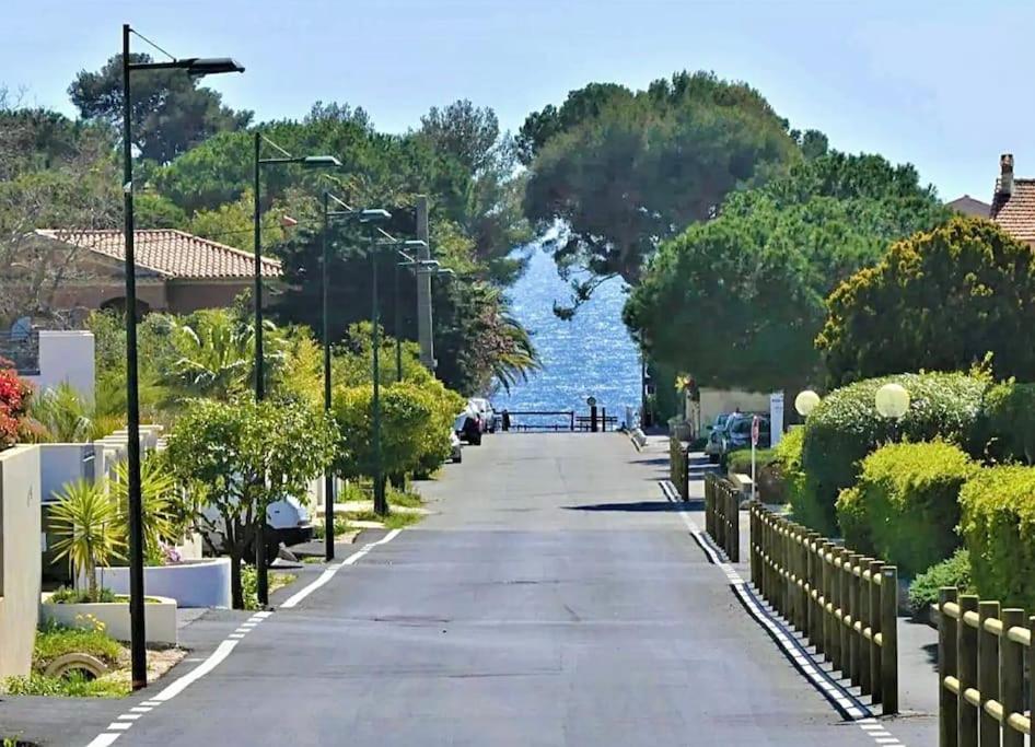 a street with a view of the water and trees at Les Jardins de Provence • Beau Rivage • Proche mer in Carqueiranne