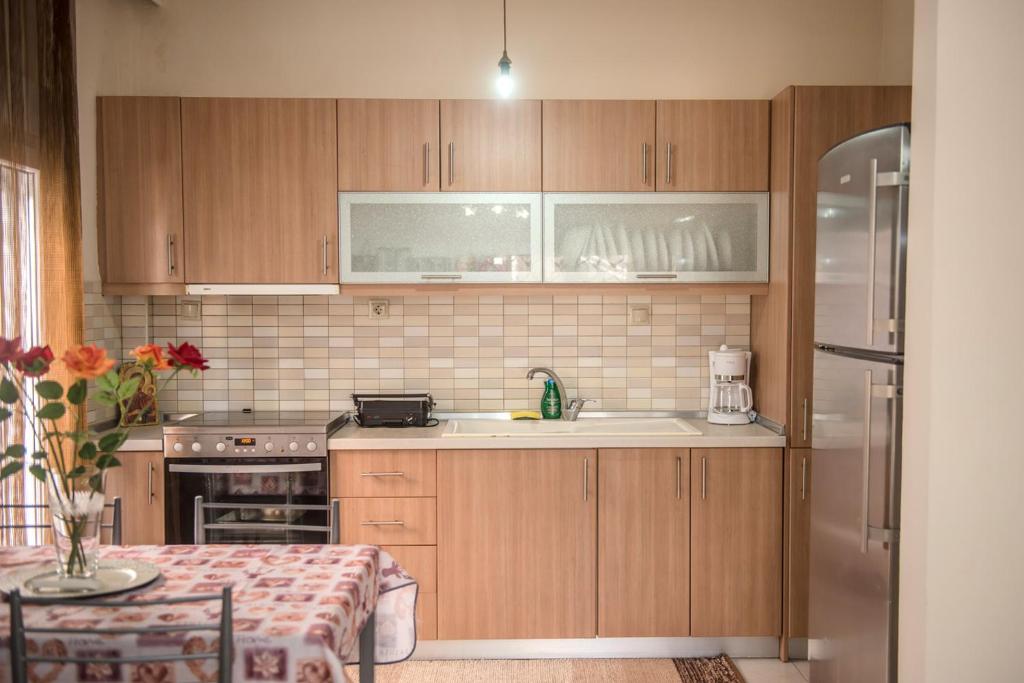 a kitchen with wooden cabinets and a sink at SAVVAS in Nea Plagia