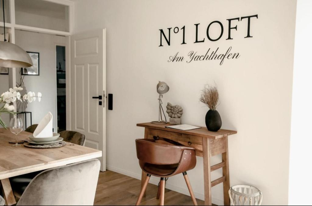 a dining room with a table and a sign on the wall at N°1 Loft Am Yachthafen in Bad Zwischenahn