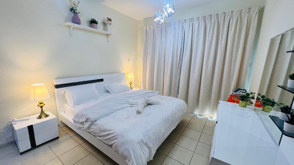 1 dormitorio con cama blanca y ventana en Newly furnished cozy ONE bed room Apartment 2 bathroom city view, en Dubái