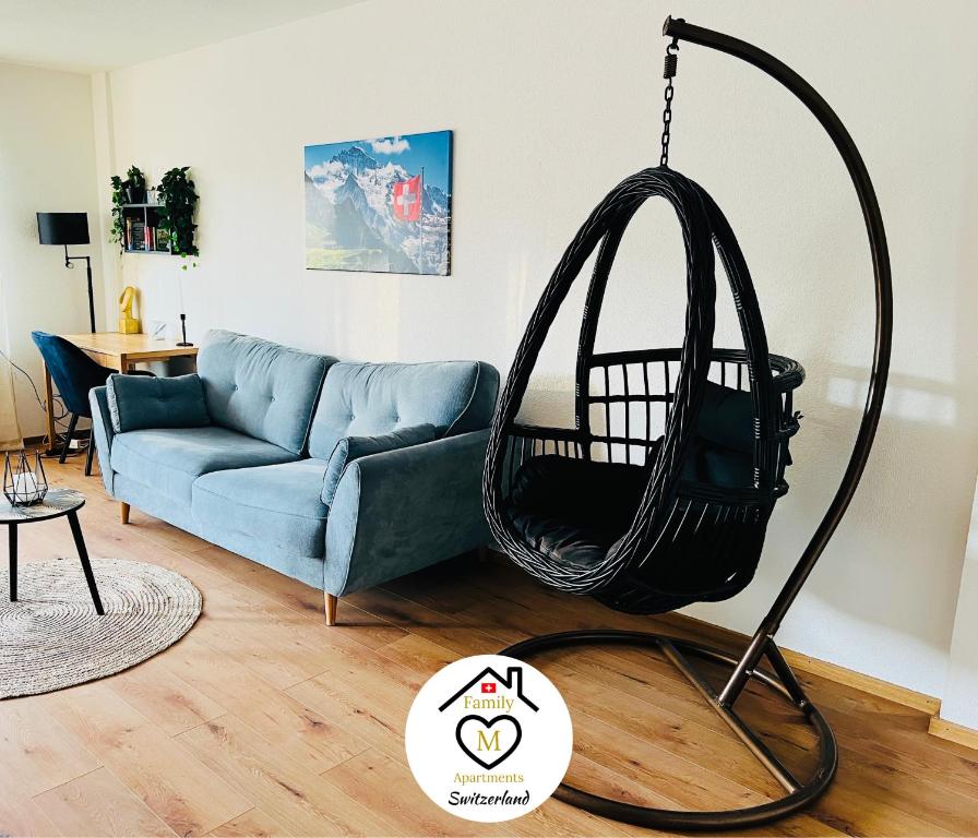 a swing in a living room with a blue couch at Family M Apartments 4-5-6 in Kappel bei Olten