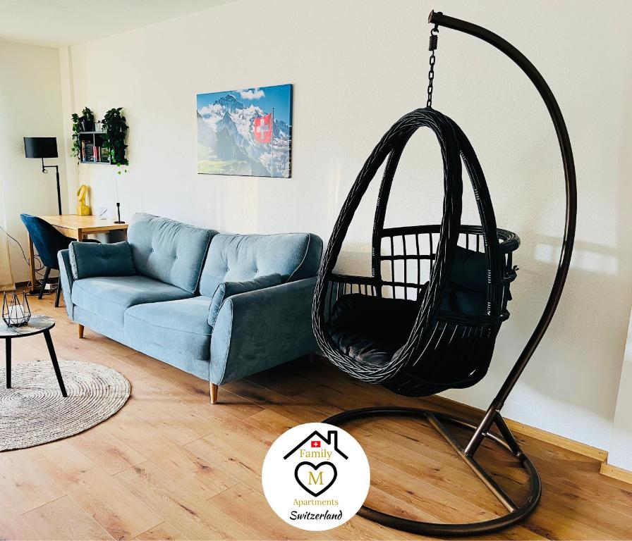 a swing in a living room with a blue couch at Family M Apartments 2-3-4 in Kappel bei Olten