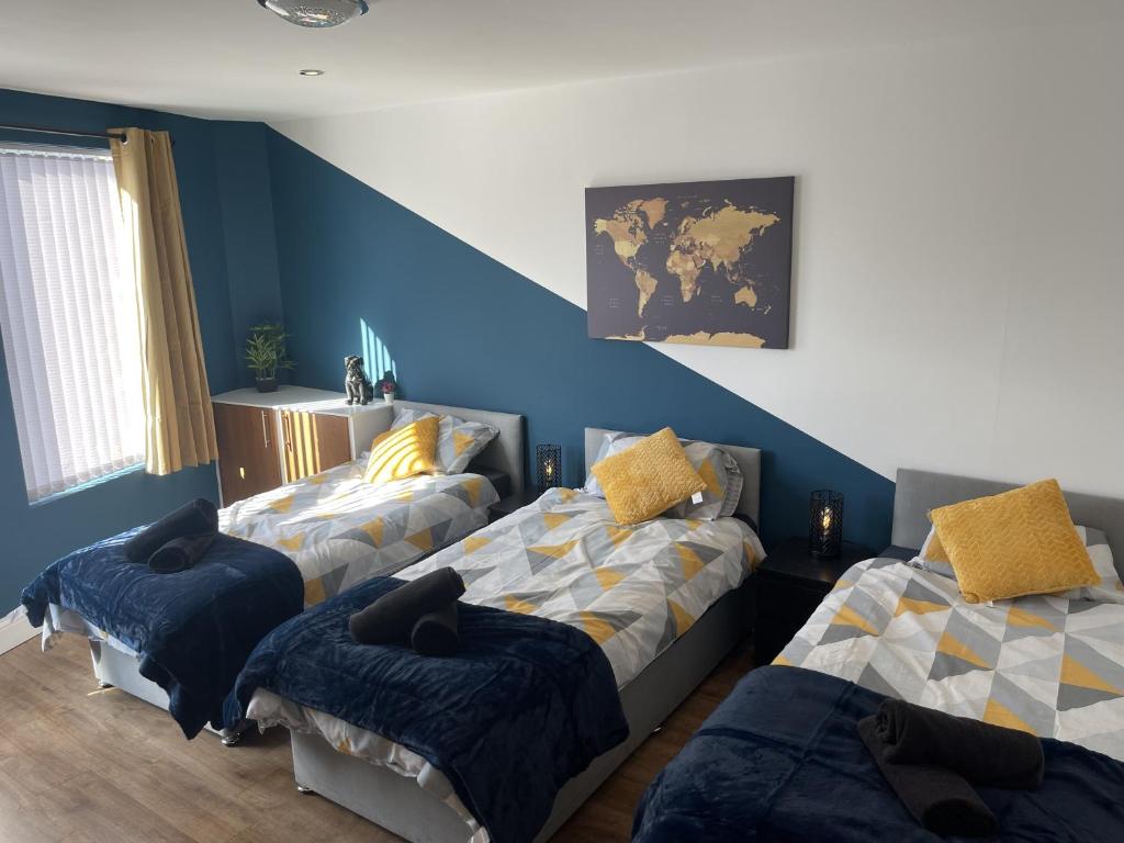 a bedroom with two beds and a blue wall at Anfield accomodation in Liverpool