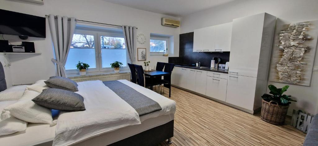 a bedroom with a large bed and a kitchen at Apartment Mario in Ptuj