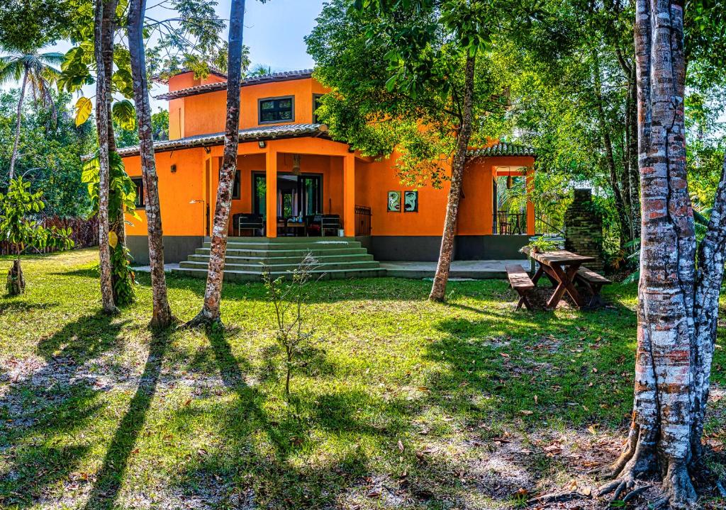 an orange house in the middle of a forest at Villa Beijaflor in Santo André