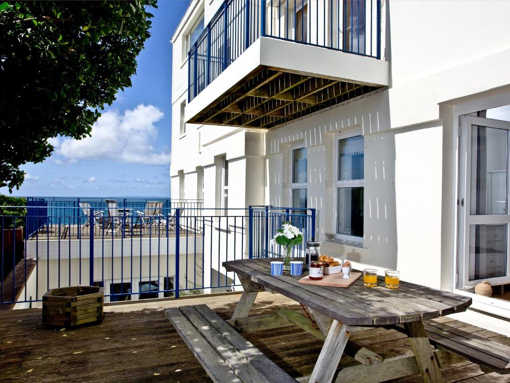 a wooden table on a balcony with a view of the ocean at 5 Devon Beach Court in Woolacombe