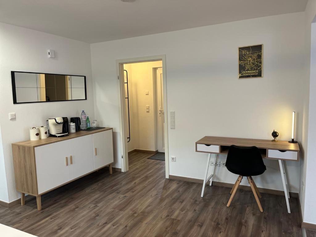 um quarto com uma secretária e uma mesa num quarto em Golden Apartment Schwabach em Schwabach