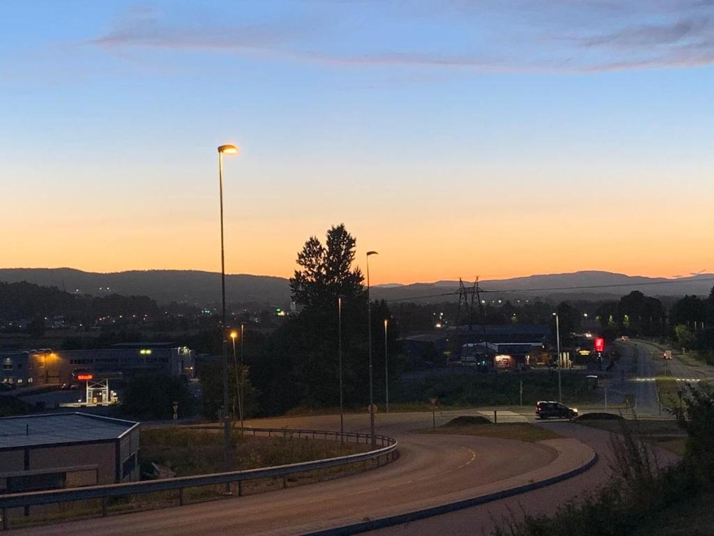 un camino con una puesta de sol en el fondo en Trivelig leilighet gratis parkering på stedet! en Porsgrunn