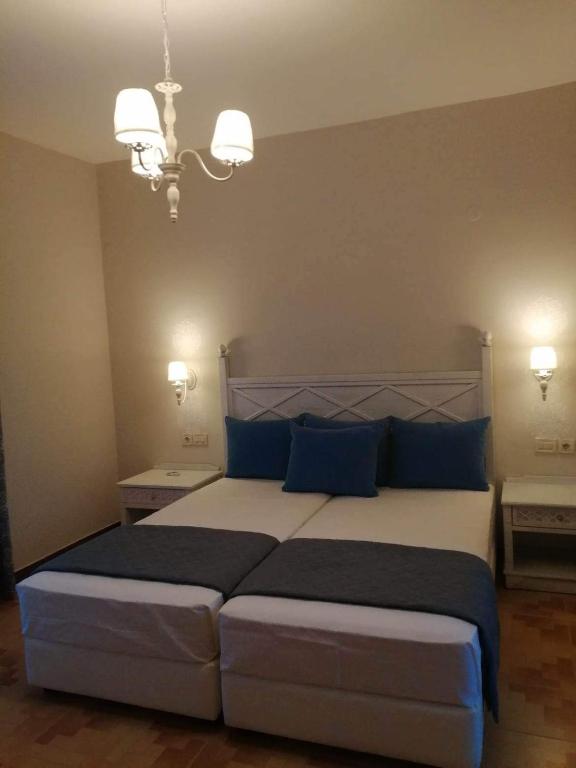 a bedroom with a large bed with blue pillows at Dionisia apartments in Kos