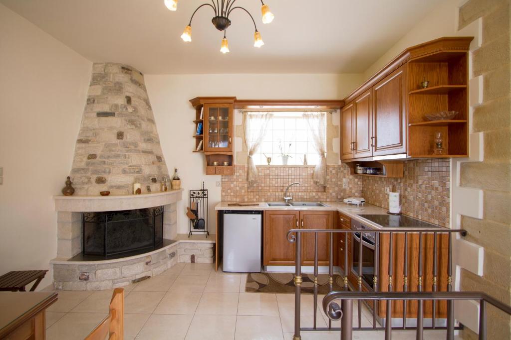 a kitchen with a stove and a stone fireplace at Sokaki House in Kalivianí