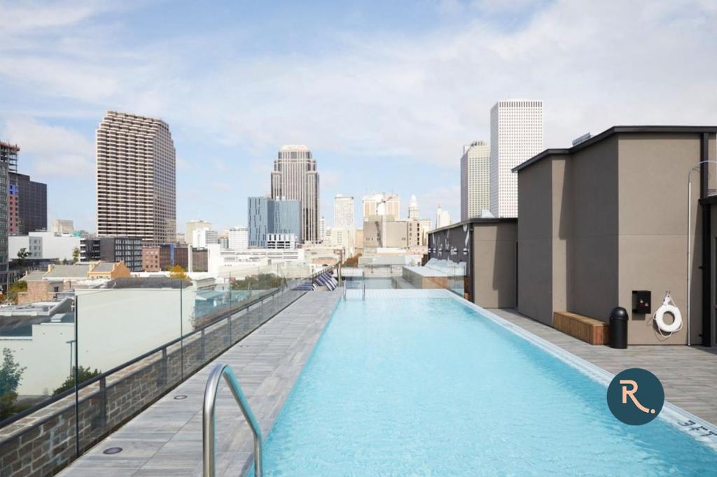 una piscina en la parte superior de un edificio con vistas al perfil urbano en Roami at The Brandywine en Nueva Orleans