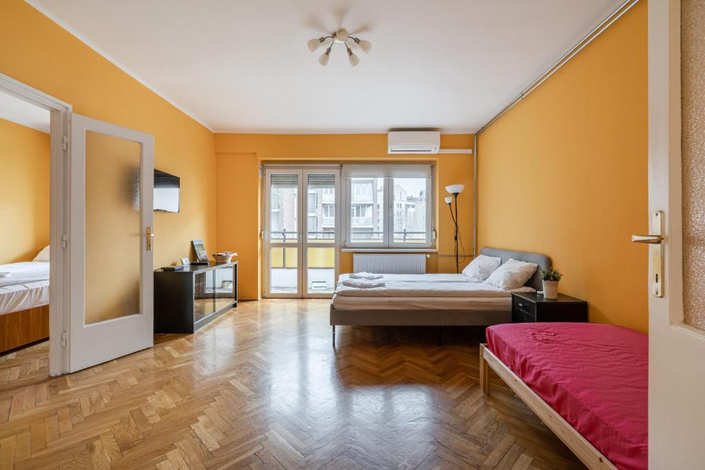 ブダペストにあるBpR Castle Point Apartmentのベッド2台、窓が備わる広い客室です。