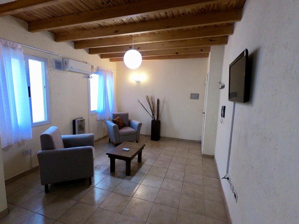 sala de estar con sillas, TV y mesa en Departamento Mi casa en Mendoza en Godoy Cruz
