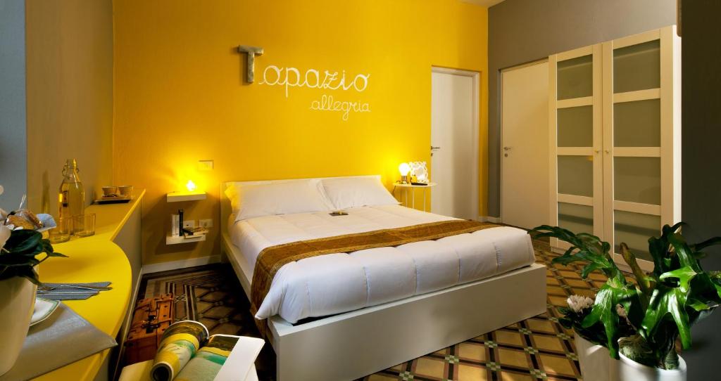 sypialnia z łóżkiem i żółtą ścianą w obiekcie GIO'EL Happiness Guest House w Bergamo