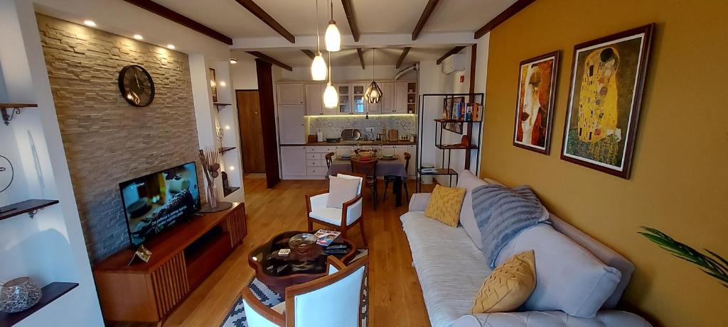 een woonkamer met een bank en een tv bij Yellow apartman in Vrnjačka Banja