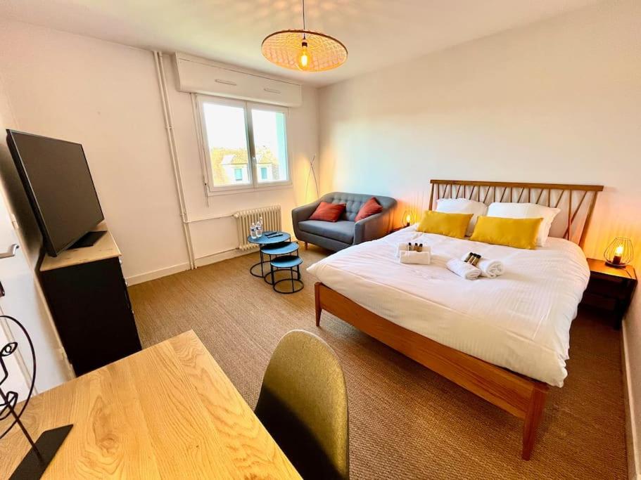una camera con un grande letto e un divano di Giena - SILS a Caen