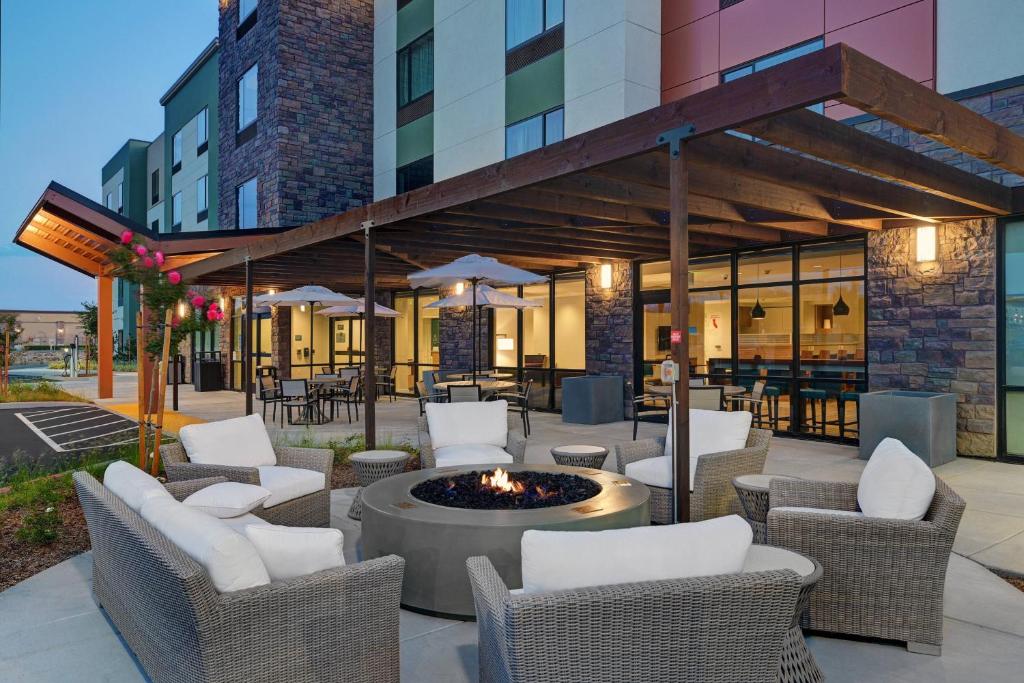 a patio with chairs and a fire pit in front of a building at TownePlace Suites Sacramento Airport Natomas in Sacramento