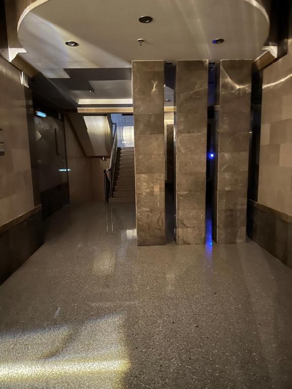 un couloir avec des colonnes en marbre dans un bâtiment dans l'établissement H.H apartments شقق مفروشة, à La Mecque