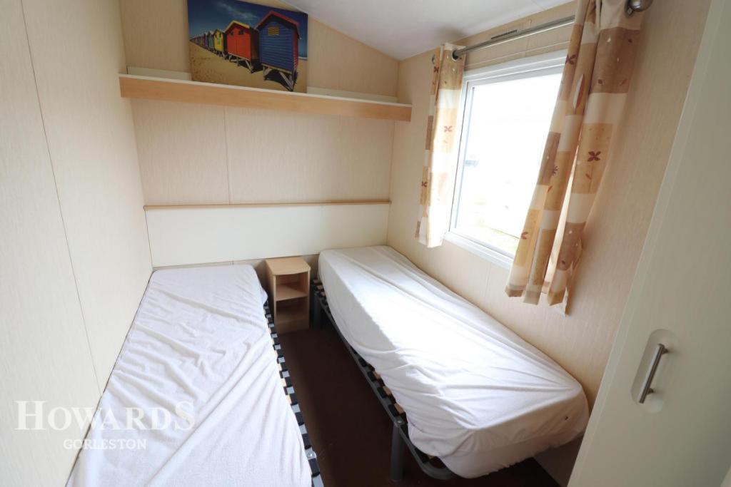 a small room with a bed and a window at 3 bed caravan Norfolk near the coast in Belton