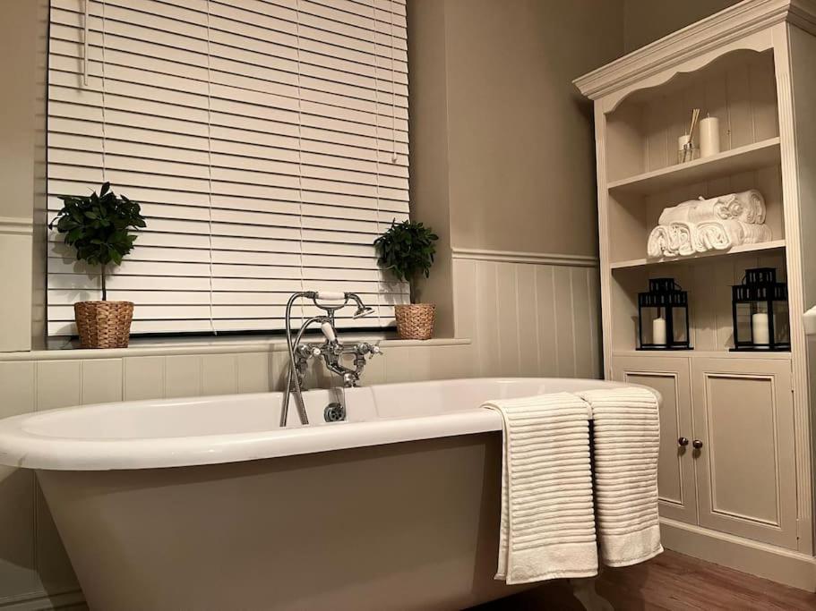 a white bath tub in a bathroom with a window at Wellington Cottage in Ilkley
