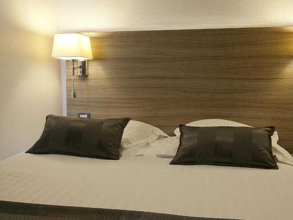 Postel nebo postele na pokoji v ubytování Hôtel le Grillon