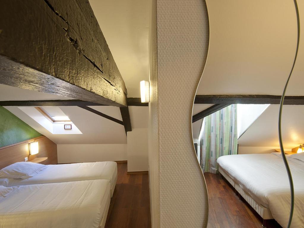 Postel nebo postele na pokoji v ubytování Hôtel le Grillon