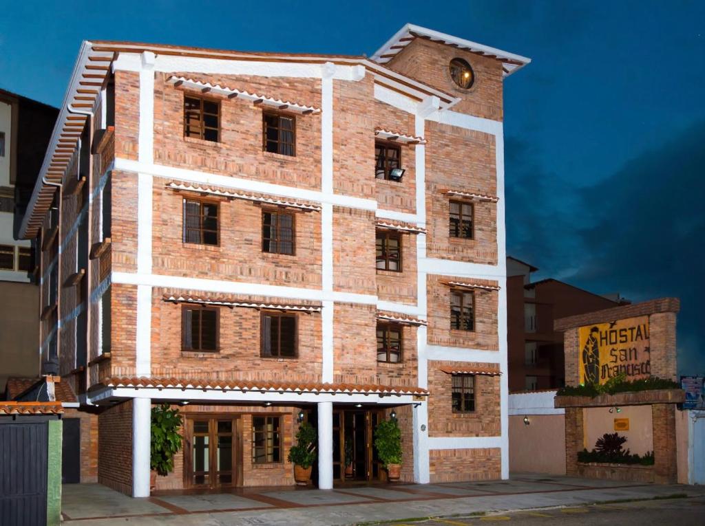 un edificio alto de ladrillo con una torre de reloj. en Hostal San Francisco en San Cristóbal