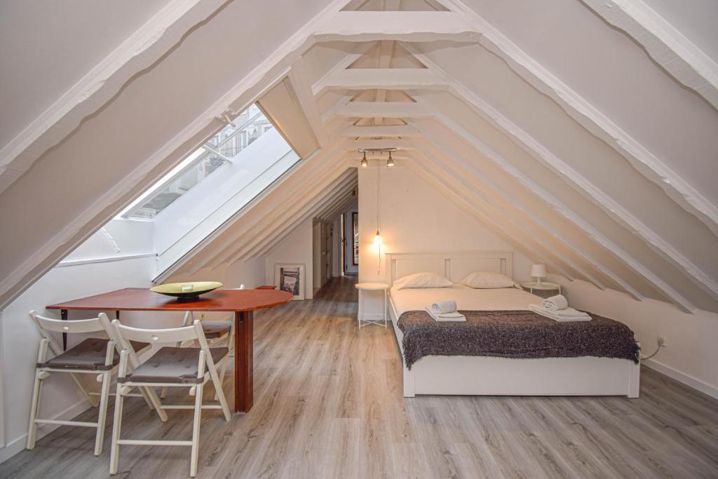 a bedroom with a bed and a table in a attic at Bica Loft in Lisbon