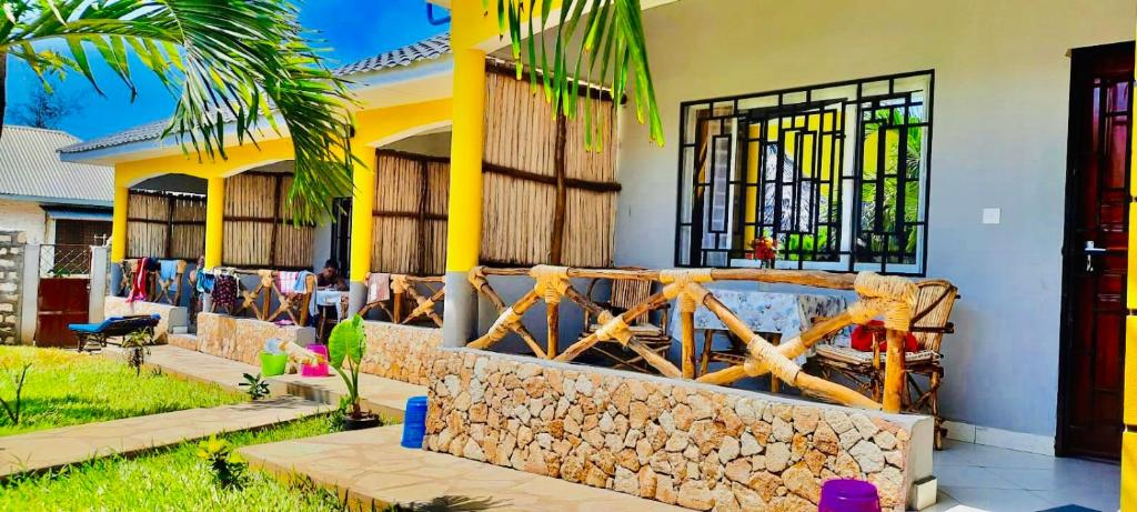 a house with a stone fence in front of it at Casa Da Luna Studios in Watamu