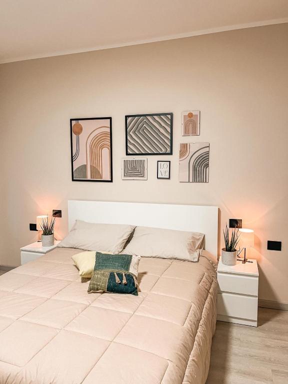 a large white bed in a bedroom with pictures on the wall at 583slm in Aosta