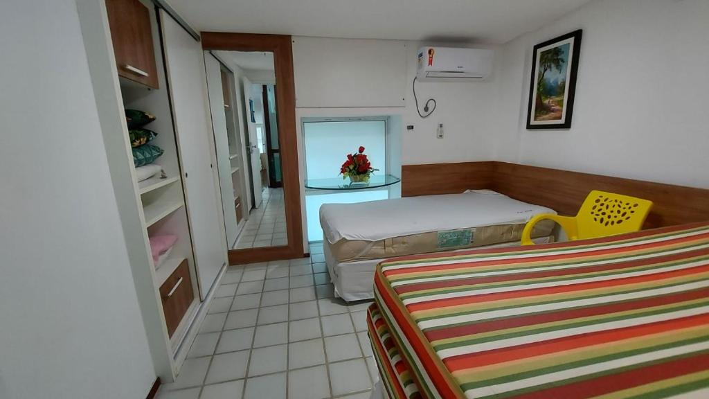 ein kleines Schlafzimmer mit einem Bett und einem Spiegel in der Unterkunft Ancorar Porto de Galinhas in Porto De Galinhas