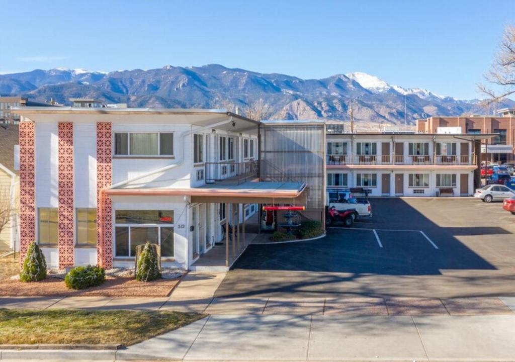 un bâtiment avec un parking et des montagnes en arrière-plan dans l'établissement Nevada Flats Hotel, à Colorado Springs