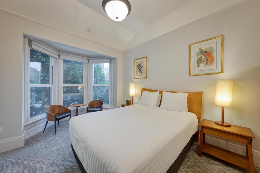 Un dormitorio con una gran cama blanca y una ventana en The Grove Inn en San Francisco