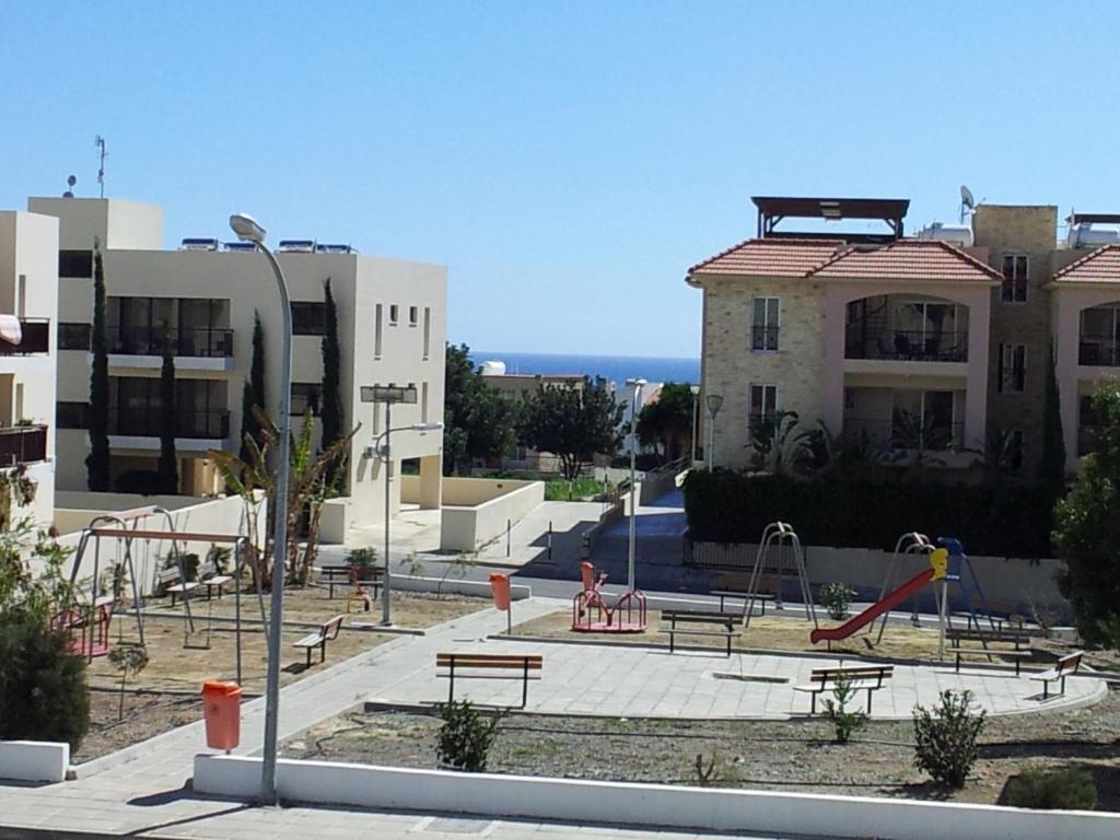 a playground with benches and slides in front of a building at Mazotos Panoramic Village in Mazotos