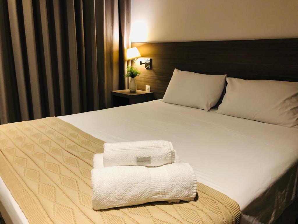 a hotel room with a bed with towels on it at Apto tipo Flat Midas Riocentro - Barra da Tijuca- Barra olímpica in Rio de Janeiro