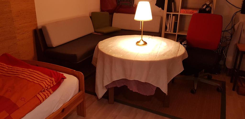 um quarto com uma mesa com um candeeiro ao lado de uma cama em Souterrain Zimmer mit Sauna em Klosterlechfeld