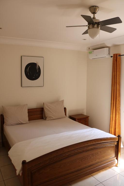 1 dormitorio con 1 cama y ventilador de techo en The Rink Apartment's en Sukuta