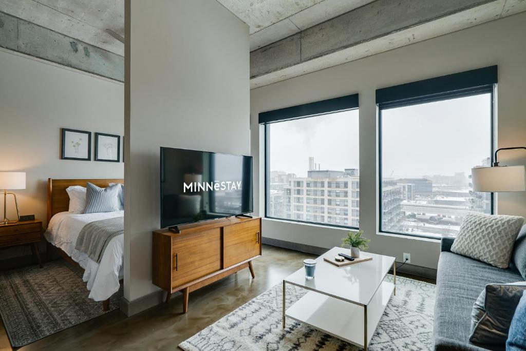 a bedroom with a bed and a tv and a couch at Sable 82 in Minneapolis